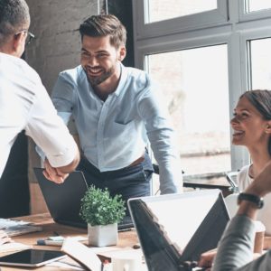 Empresarios reunidos em mesa se cumprimentam -blog da Bertha